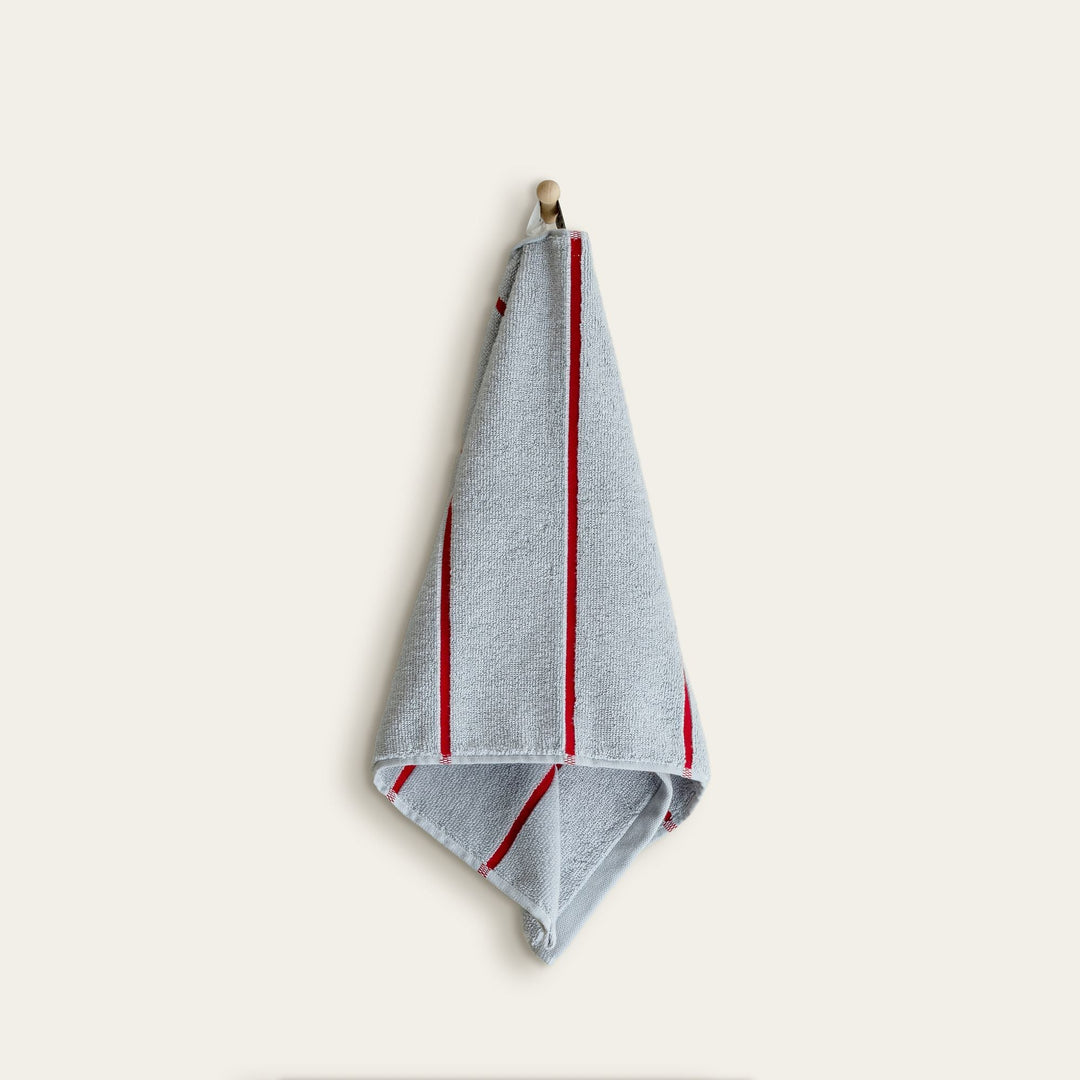 Light blue cotton towel with red vertical stripes and stitched edges