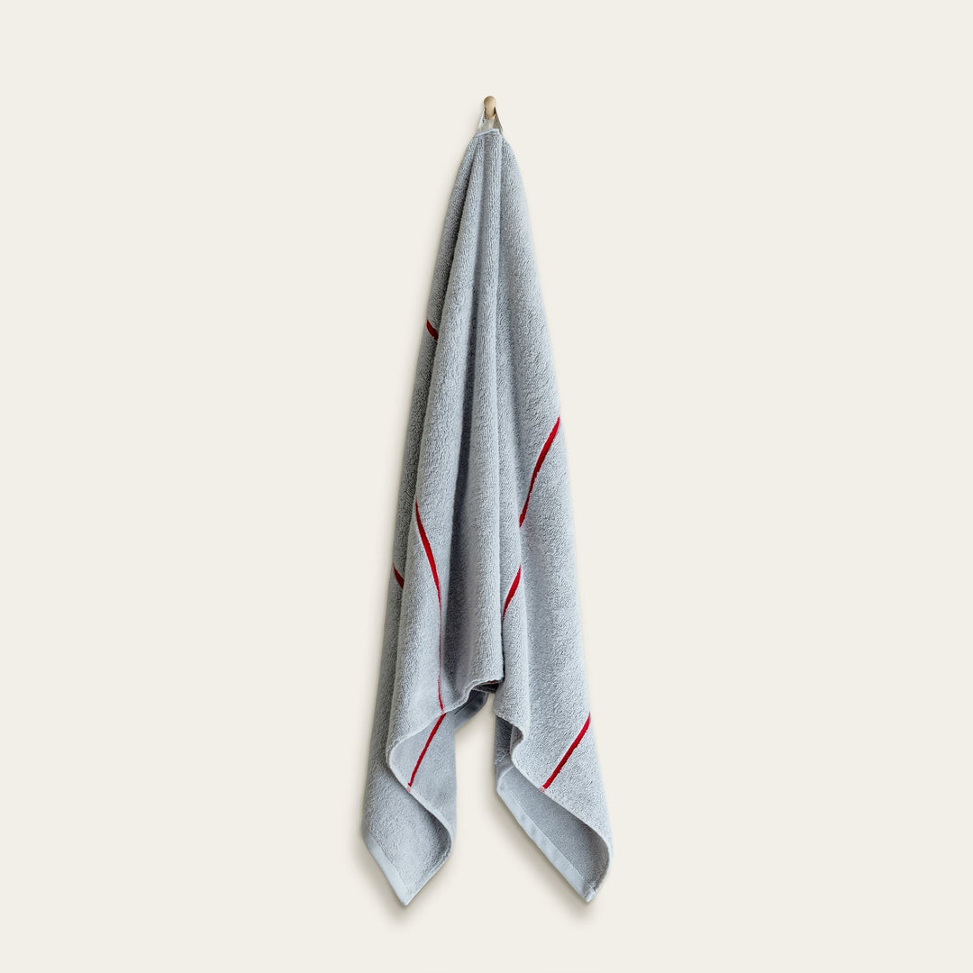 Light blue cotton towel with red vertical stripe accents, folded