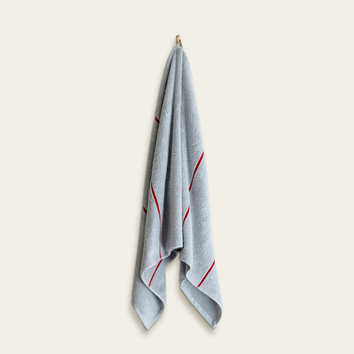 Light blue cotton towel with red vertical stripe accents, folded