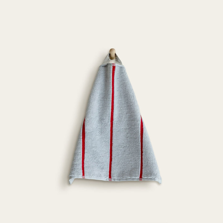 Light blue cotton towel with red vertical stripe bands, neatly folded