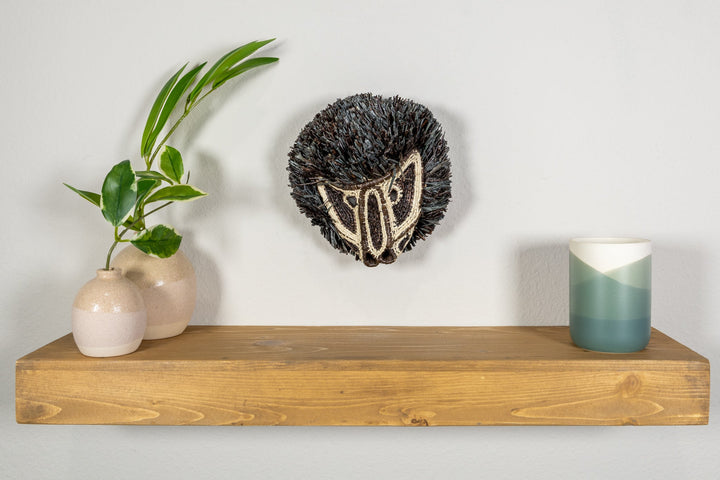 Colobus monkey mask on clear stand with dark fringe and cream embroidered face