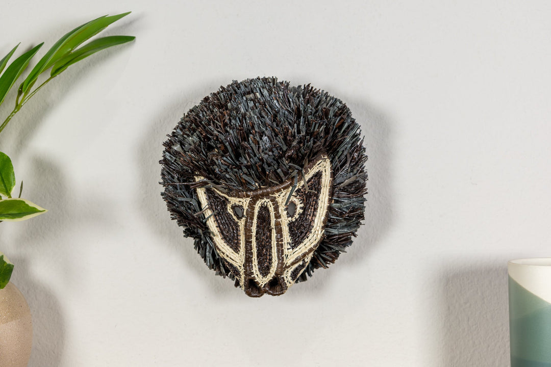 Colobus monkey mask angled view with dark shag fringe and cream embroidered face