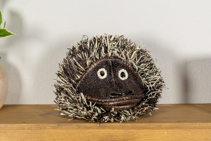 Tufted capuchin monkey mask, tufted hood framing stitched snout and mouth.