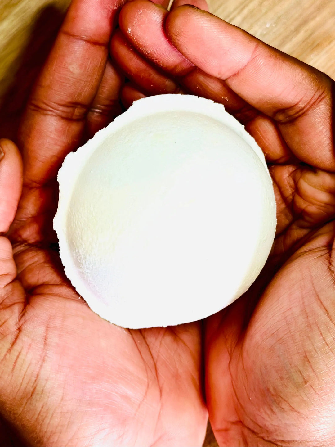 White round shower steamer disc in hands, close-up
