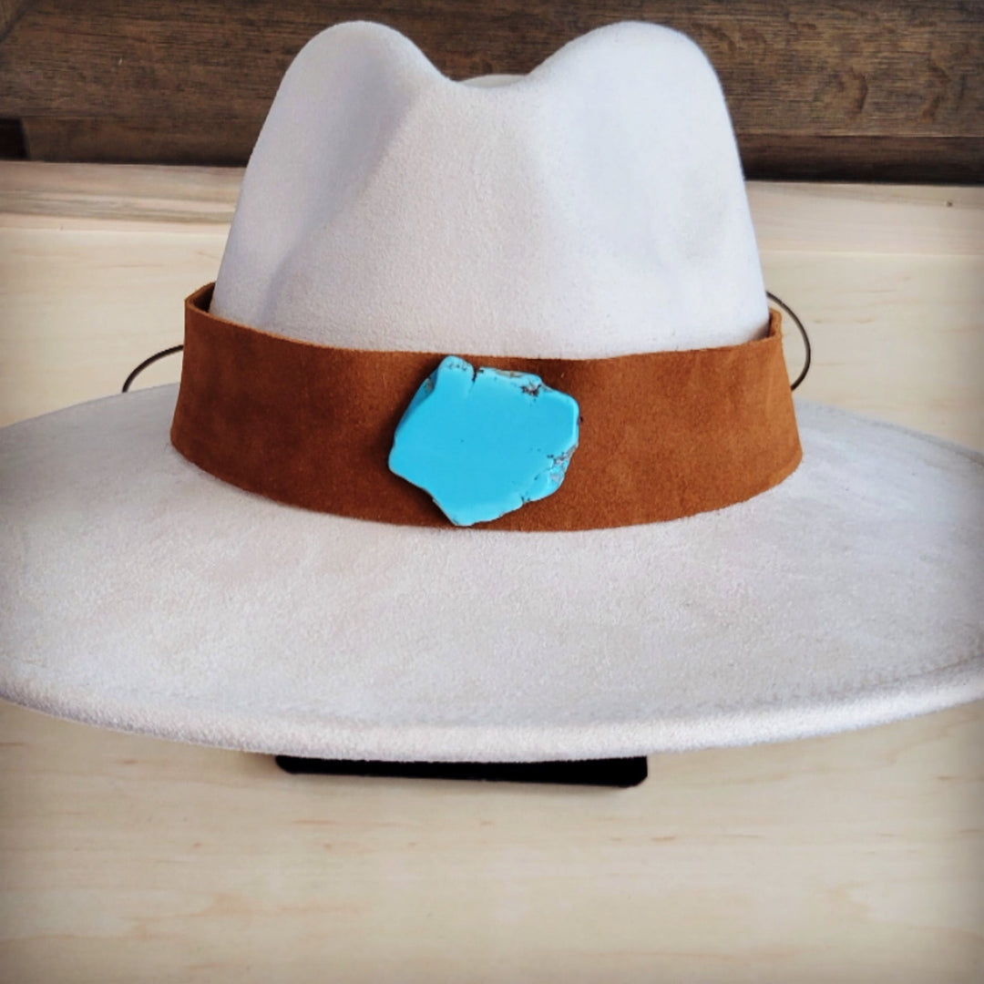 Wide tan suede hat band with turquoise center patch on white felt hat