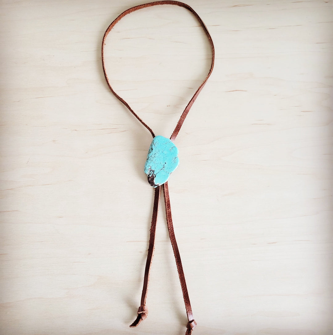Brown leather lariat necklace featuring a turquoise slab center and hanging tie cords