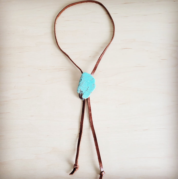 Brown leather lariat necklace featuring a turquoise slab center and hanging tie cords