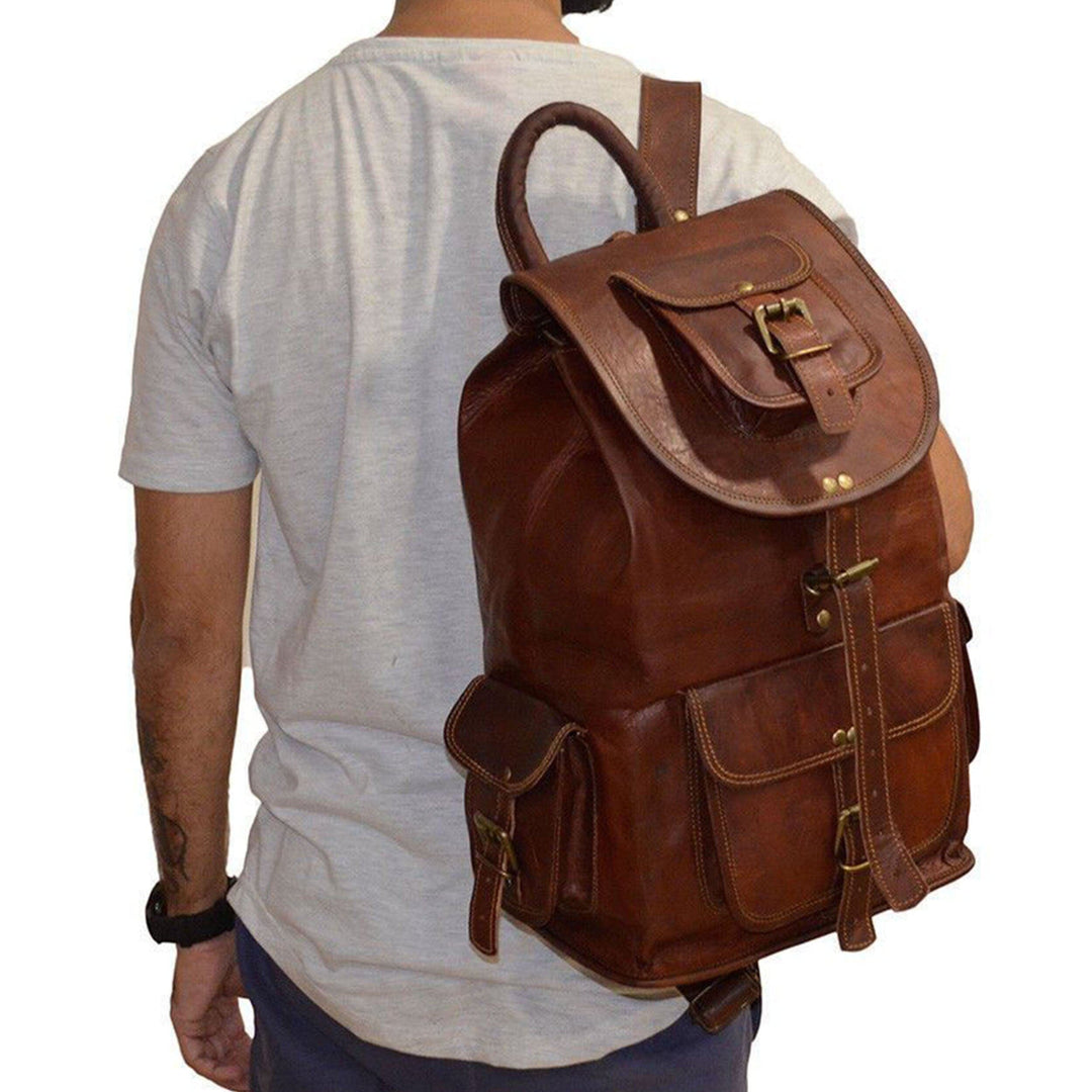 Brown leather backpack worn on model, side pockets and adjustable shoulder straps.