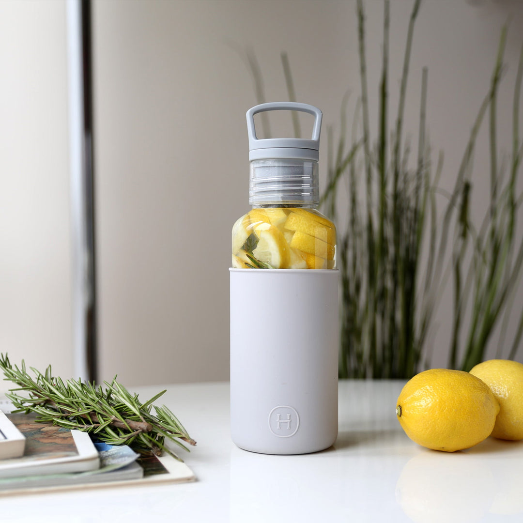 20 oz grey bottle with clear infuser, filled with lemon slices and rosemary