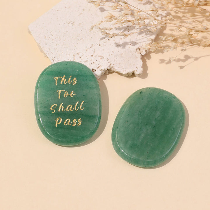 Green oval crystal stone with gold text reading “This Too Shall Pass”