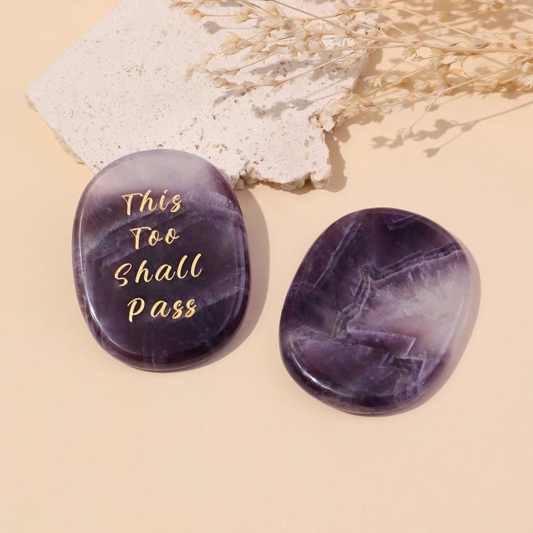 Purple oval crystal stone set with gold “This Too Shall Pass” text