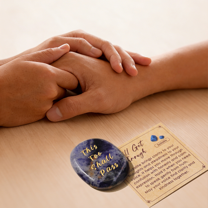 Blue heart-shaped crystal stone with gold lettering, beside instruction card
