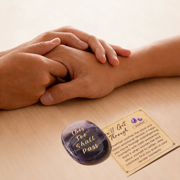 Purple heart-shaped crystal stone with gold lettering, beside instruction card