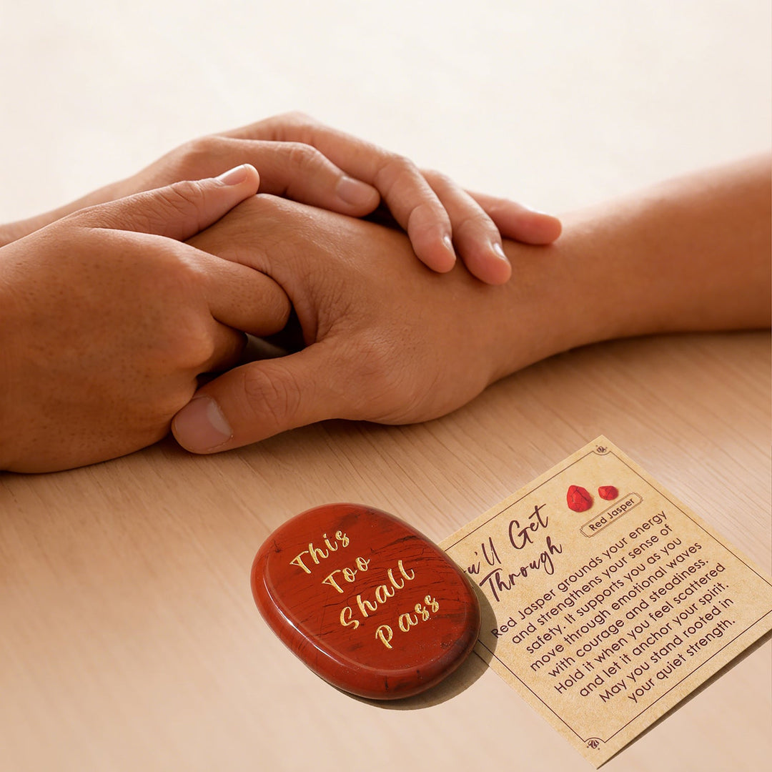 Red heart-shaped crystal stone with gold lettering, beside instruction card