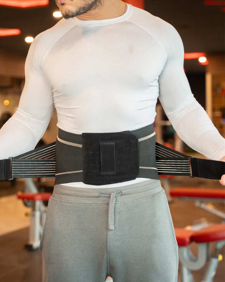 Black lower back brace worn over white shirt with central padded support
