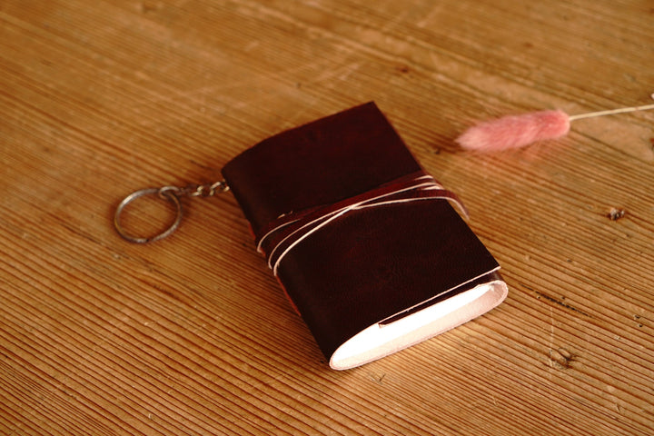 Distressed leather mini journal with keychain ring and wrap strap, dark red-brown