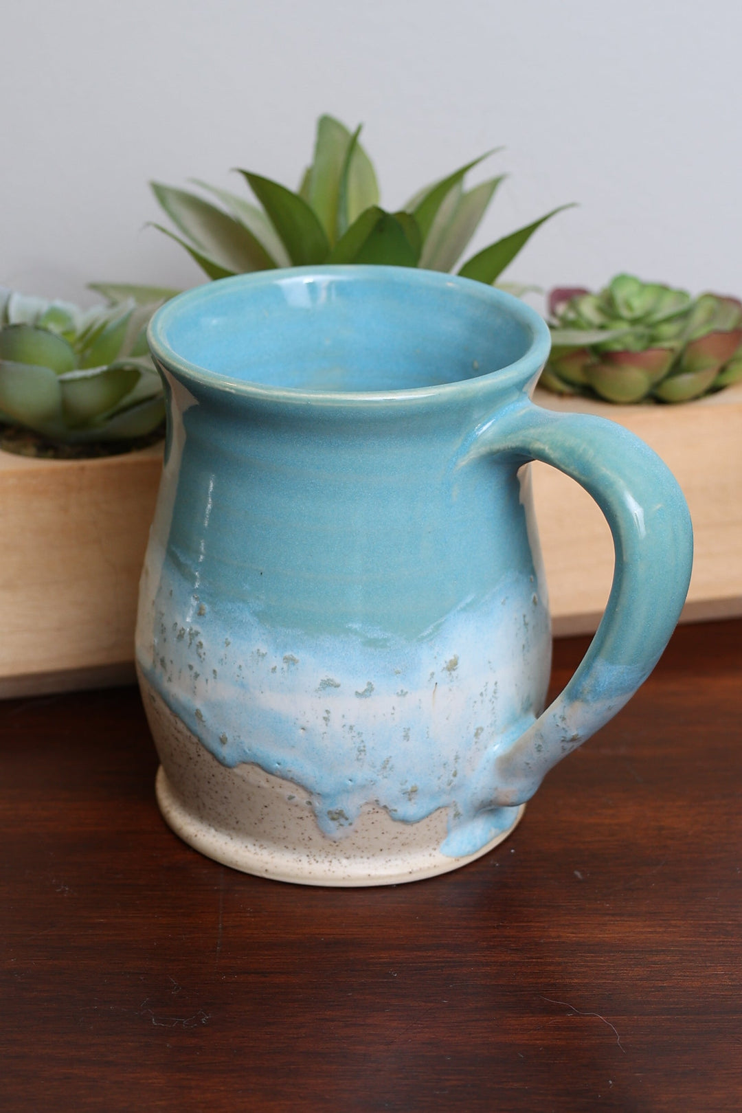 Blue ceramic mug with speckled coastal glaze, curved handle, wide rim