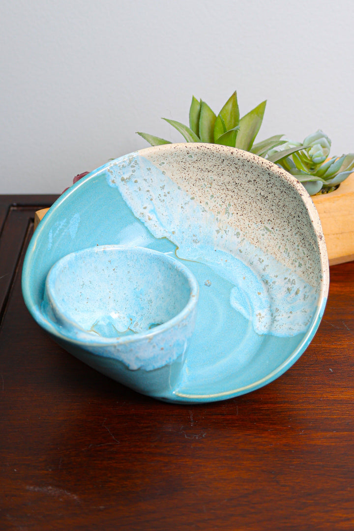 Coastal ceramic serving bowl with blue interior and beige speckled outer glaze