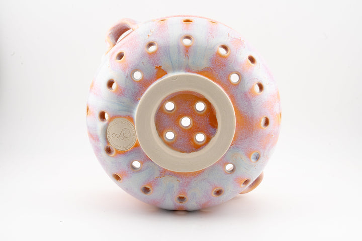 Top view of handmade ceramic berry colander bowl with perforated holes and circular drain