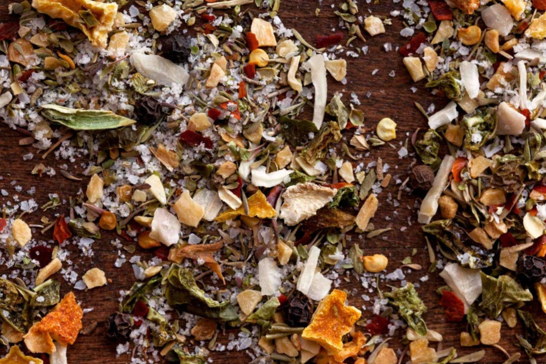 Crushed dried herbs and spice bits scattered on a dark surface