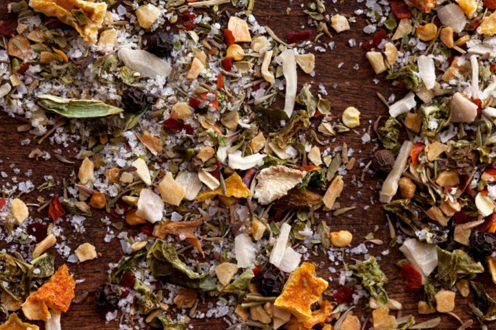 Crushed dried herbs and spice bits scattered on a dark surface