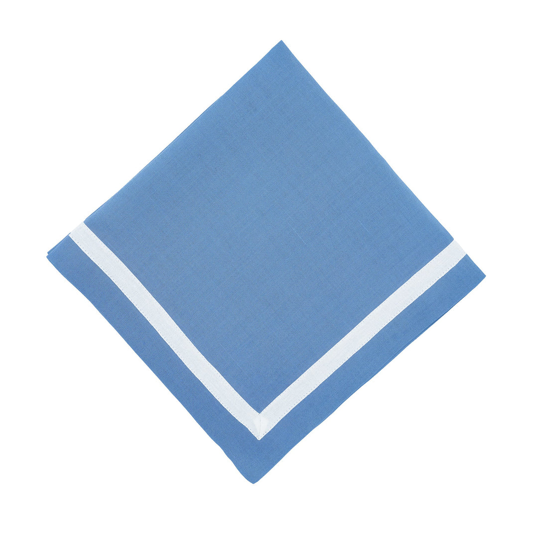 Blue linen napkin with white border, folded into a diamond
