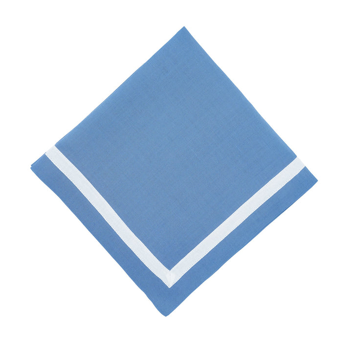 Blue linen napkin with white border, folded into a diamond