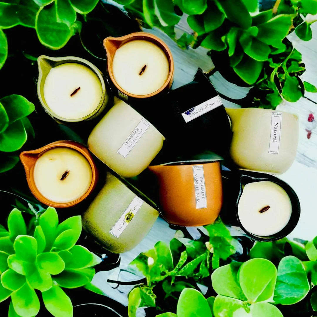 Body oil serum candle set with teal-green jars and white wax flames
