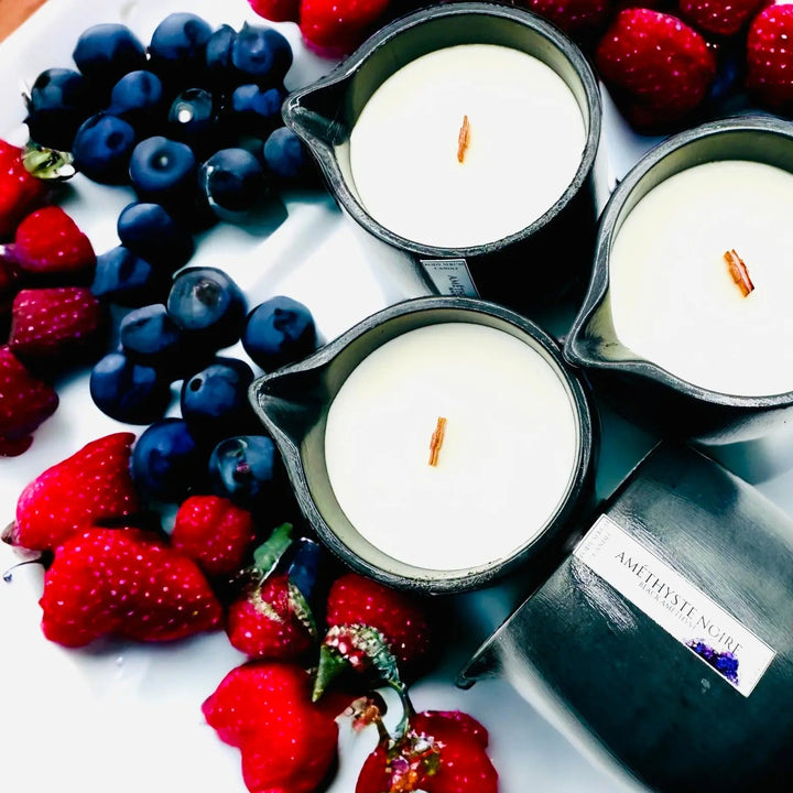 Body oil serum candle in dark metal cups with white wax and exposed wicks