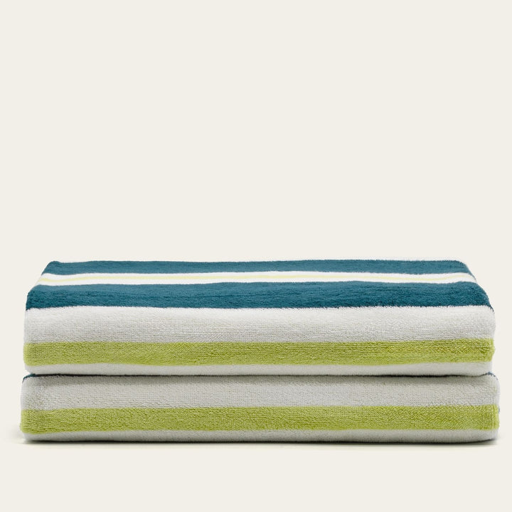 Cotton beach towels stacked with teal, white, and light green stripe bands