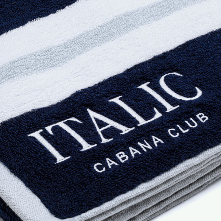 Close-up of navy cotton towel with white "ITALIC" and "CABANA CLUB"