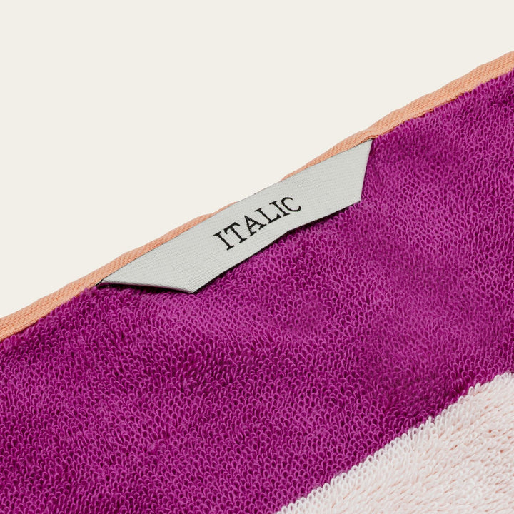 Cotton beach towel with ITALIC logo label on purple terry fabric