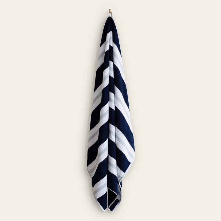Hanging cotton beach towel with navy and white diagonal stripe pattern