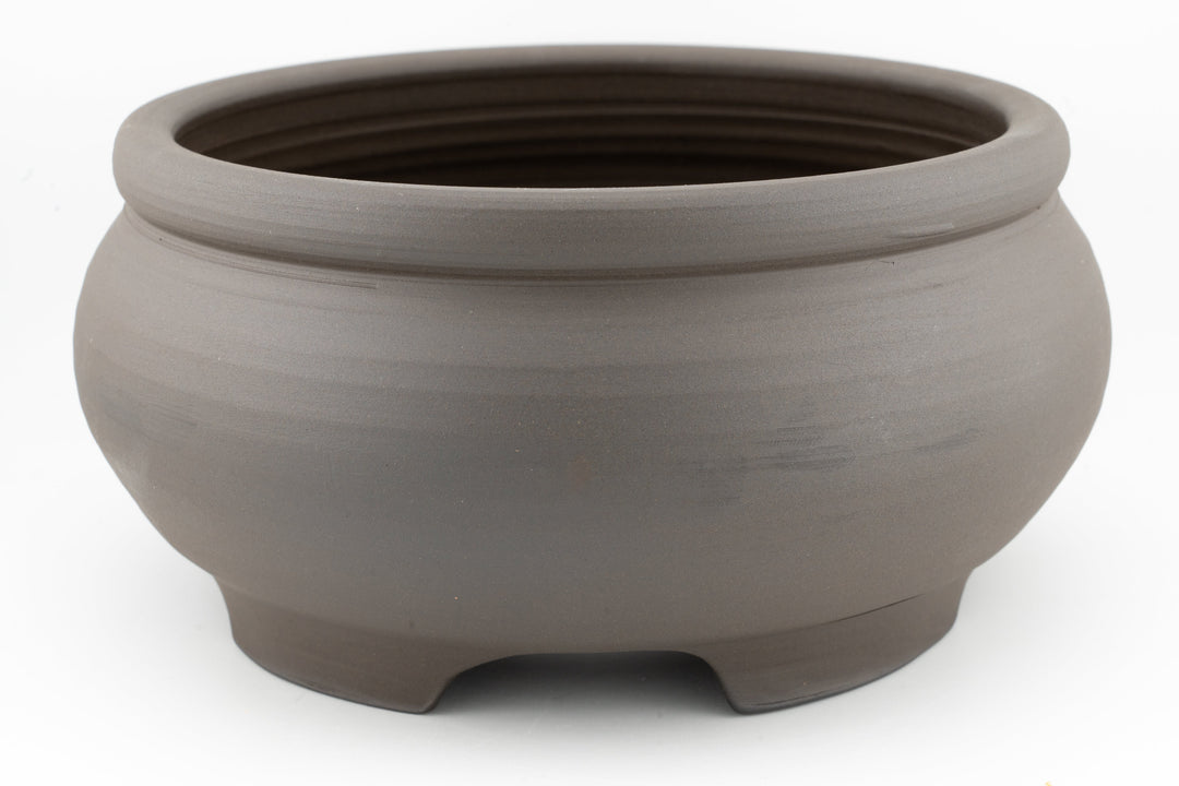 Unglazed dark brown stoneware bonsai pot with three-foot base and round rim