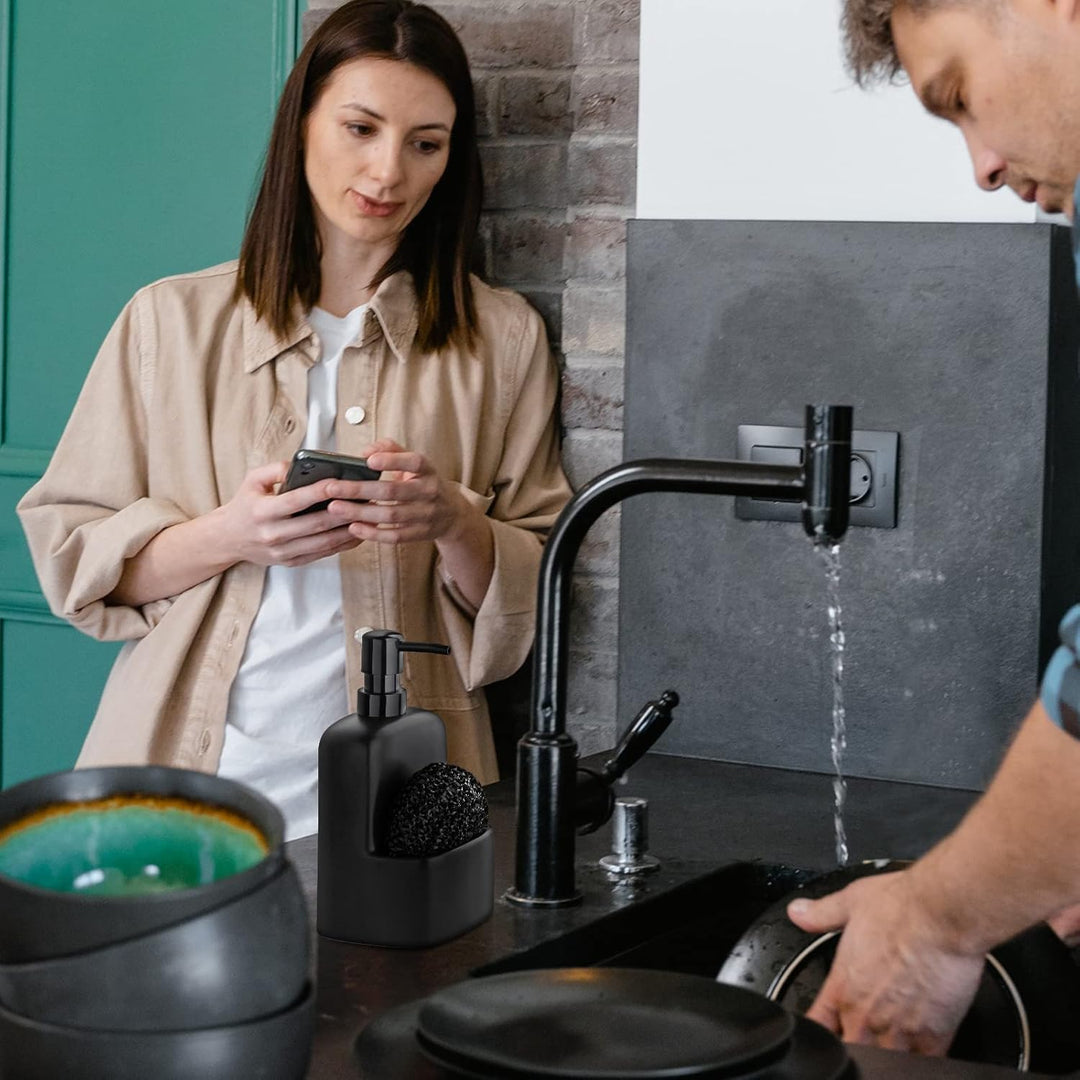 Matte black soap dispenser with attached sponge holder and scrub pad by sink