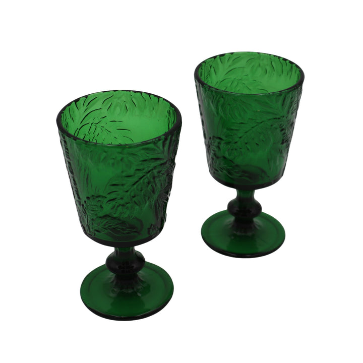 Green botanical-imprinted glass goblets with stems and round bases, two shown.