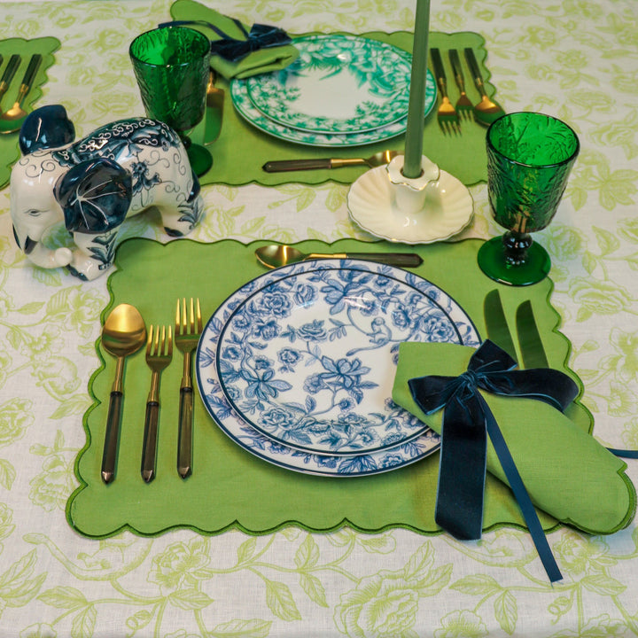 Green botanical-imprinted goblets on a table setting with plates and cutlery.