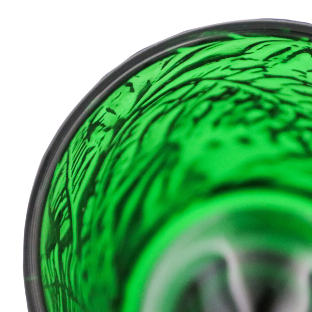 Close-up of green botanical-imprinted glass goblet rim and textured pattern.