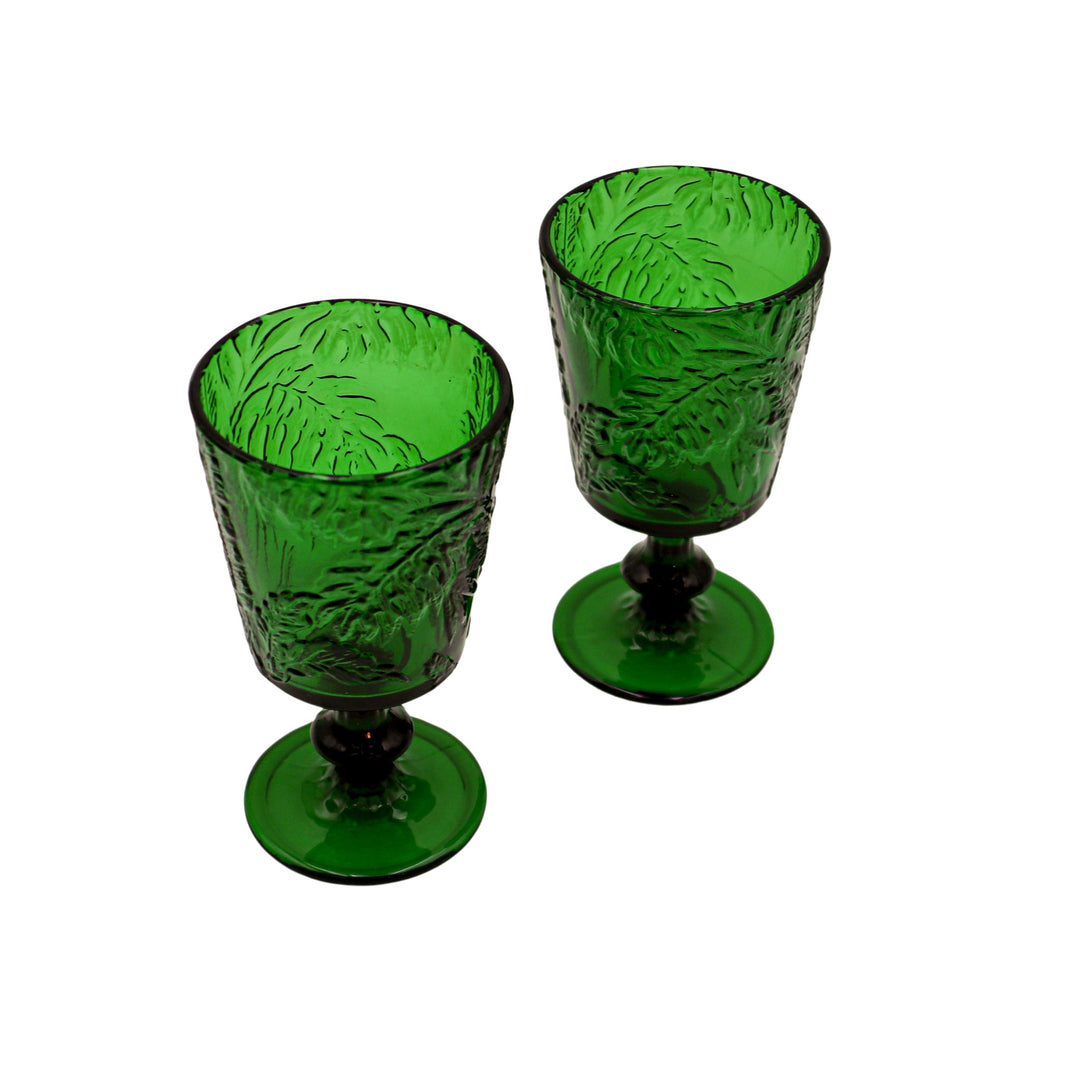 Green botanical-imprinted glass goblets with stems and round bases, two shown.