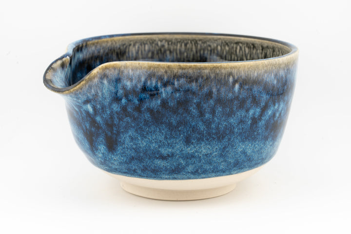 Dark blue ceramic bowl with side spout and white base