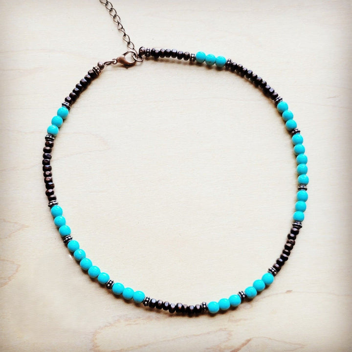 Turquoise blue bead collar necklace with dark bead accents and copper-tone chain.