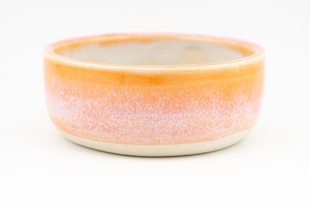 Ceramic condiment cup with coral-orange speckled exterior and cream interior