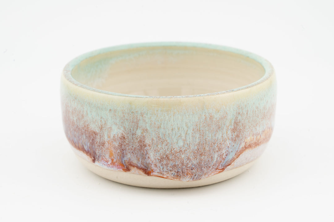 Ceramic condiment cup with cream base and multicolor speckled glaze, teal and orange tones
