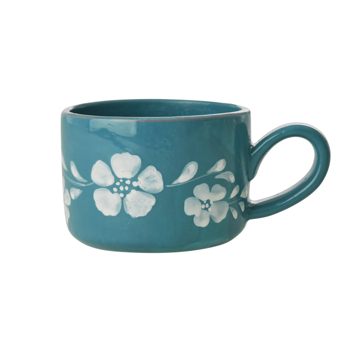 Teal ceramic cappuccino cup, side view, with white floral vine and loop handle