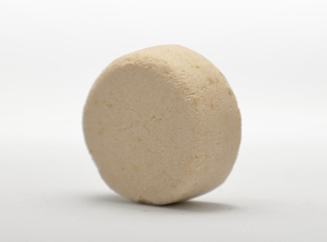 Beige round shampoo bar with smooth textured surface