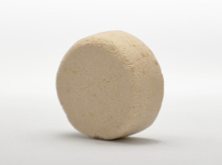 Beige round shampoo bar with smooth textured surface