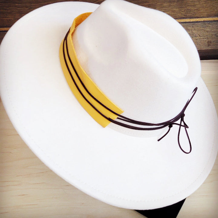 White felt hat with mustard leather band and black lace-up cords at side