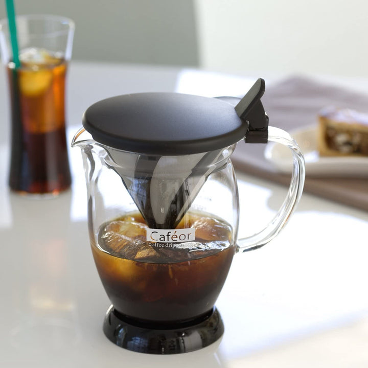 Hario Caféor coffee dripper with glass carafe and black lid, filled with iced coffee