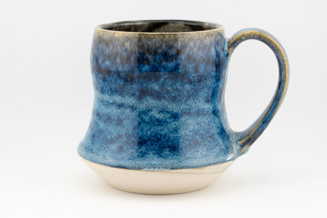 Blue speckled tall ceramic mug with curved handle and rounded base