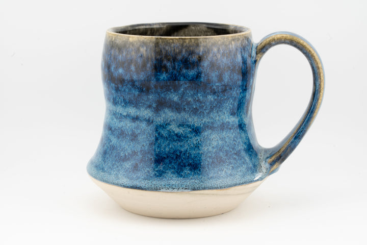 Blue speckled tall ceramic mug with curved handle and rounded base